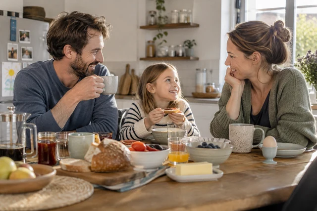 Symbolbild: Familie im Gespräch am Frühstückstisch