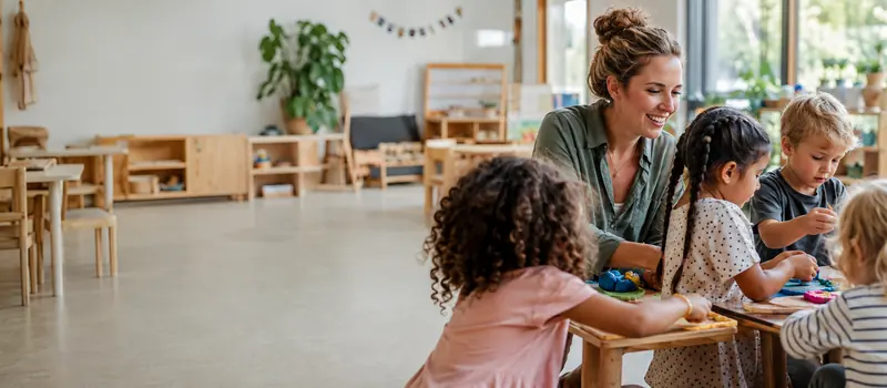Erzieherin bei einer kreativen Aktivität mit Kindern in einer Kita