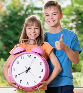 Junge und Mädchen lernen die Uhr