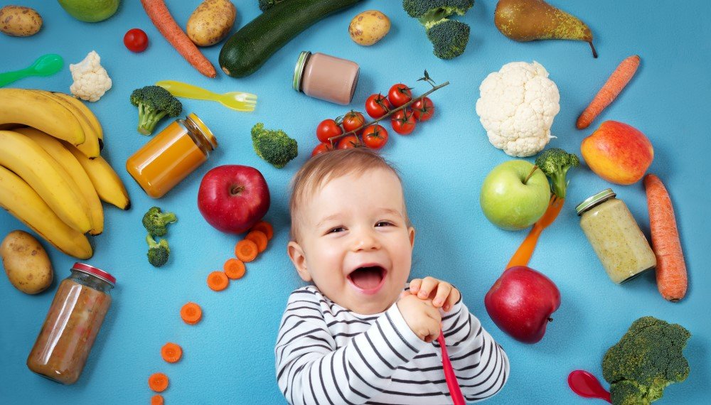 Baby umgeben mit Obst und Gemüse
