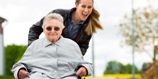 Frau mit Großmutter im Rollstuhl