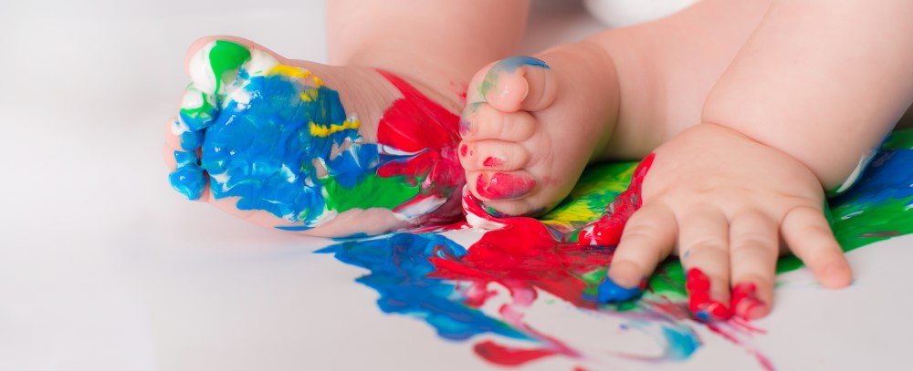 Baby spielt mit Fingerfarben