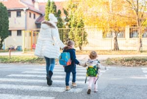 Mutter mit zwei Kindern auf dem Schulweg