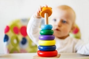 Baby spielt ein Spiel mit Holzklötzen