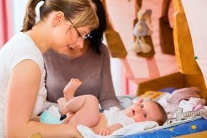hebamme kontrolliert das gewicht eines babys