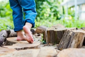 ein kind wandert ueber einen barfusspfad