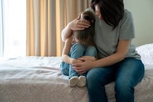 mutter troestet ihre kleine Tochter