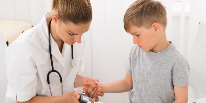 Ärztin misst Blutzucker beim kleinem Jungen