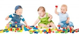 drei babys spielen mit baukloetzen