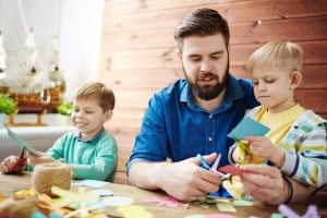 Erzieher bastelt mit Kindern