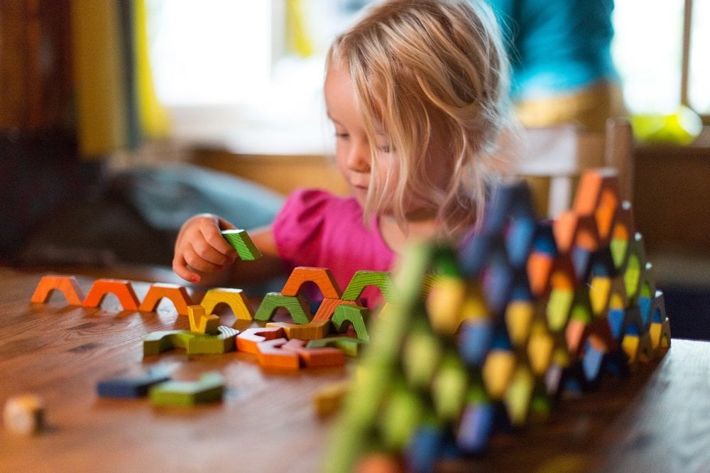 Mädchen spielt mit Bauklötzen am Tisch