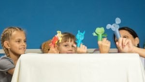 eine familie spielt gemeinsam mit fingerpuppen
