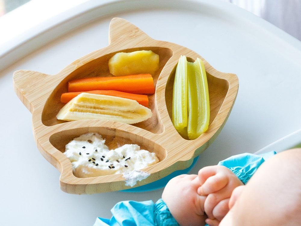 Ernährung im ersten Lebensjahr: Stillen, Flasche und Beikost gesunde speisen auf einem baby-teller