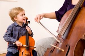 Kind und Frau spielen Cello