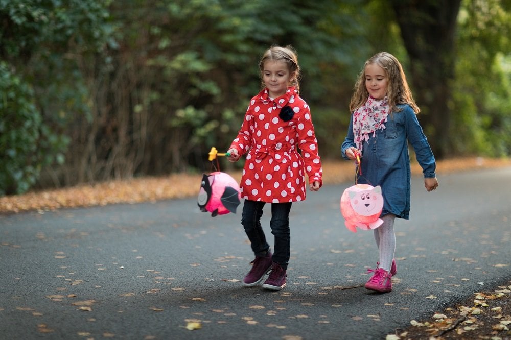 Laternenfest im Kindergarten – Bedeutung und einfache Ideen Kinder gehen mit einer Laterne die Straße entlang