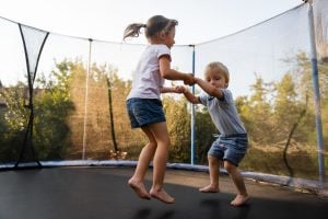 Kinder springen zusammen Trampolin