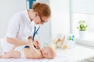 Kinderärztin untersucht ein Baby