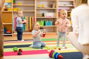 kleine kinder mit spielzeug in kindergarten