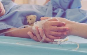 mutter hält hand von krankem kind im krankenhaus