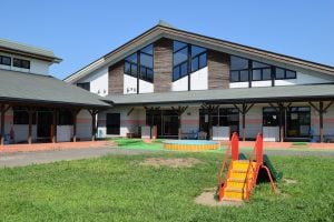 Kitagebäude von außen mit Spielplatz
