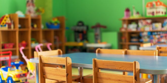 Raum mit Spielsachen, Tisch und Stühlen einer Kita ohne Kinder