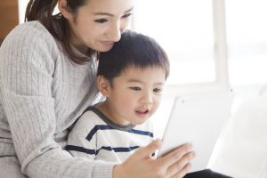 Mutter und Kind schauen auf ein Tablet