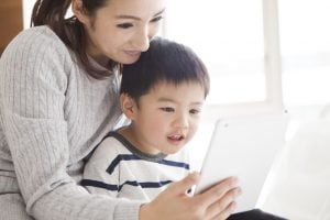 Mutter und Kind schauen auf ein Tablet
