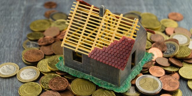 Miniaturhaus steht auf Kleingeld