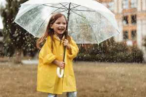 Mädchen mit Regenjacke und Regenschirm 