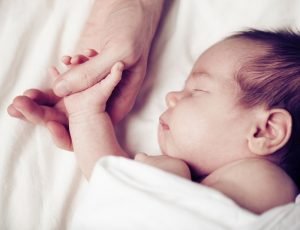 Baby hält die Hand seines Vaters