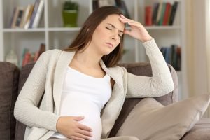 schwangere frau mit kopfschmerzen