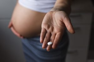 schwangere frau mit tablette in der hand