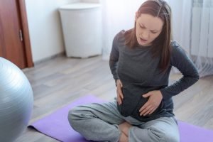 schwangere Frau verspürt während des Trainings Schmerzen