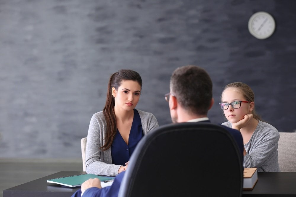 mutter mit ihrer tochter in einem gespraech mit dem lehrer