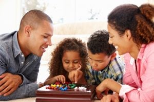 eine familie spielt gemeinsam ein brettspiel