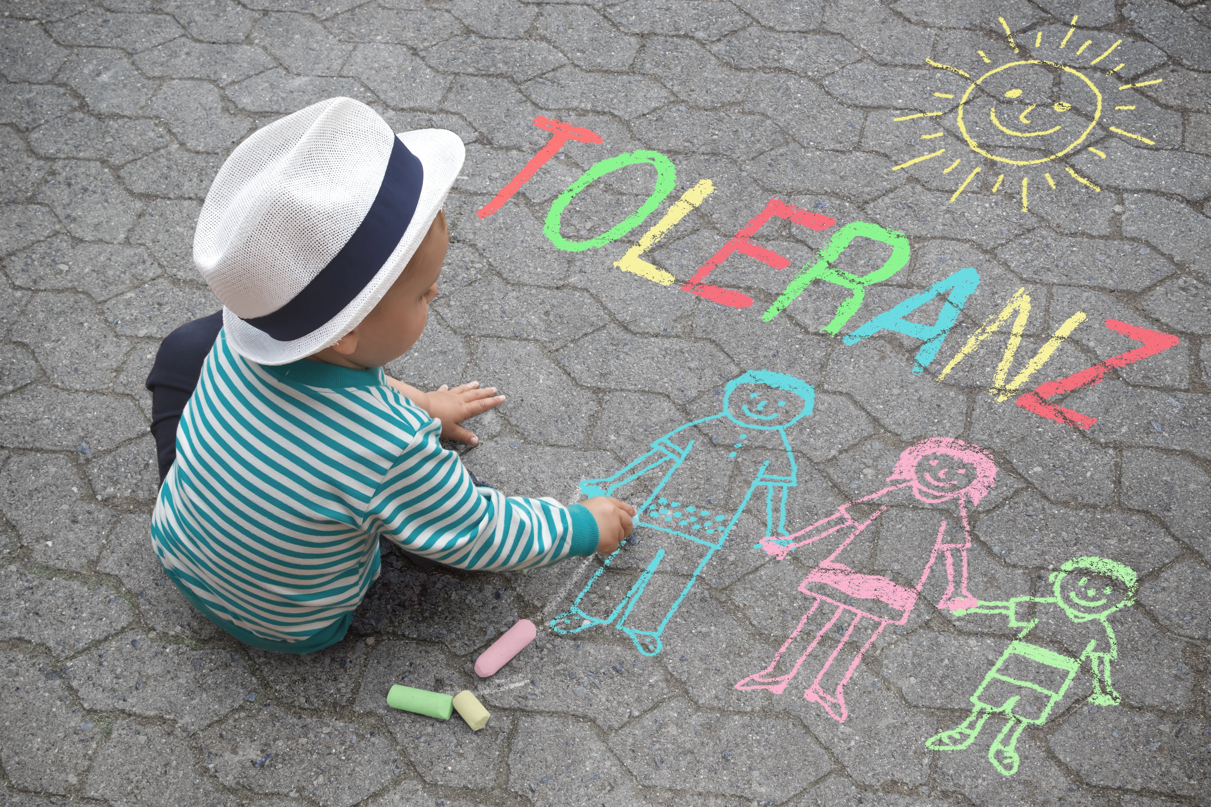 Kind malt mit Kreide Wort Toleranz