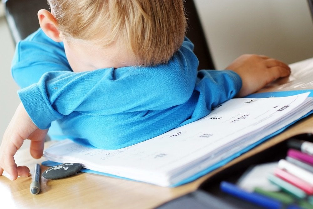 überforderter Junge über Schulaufgaben