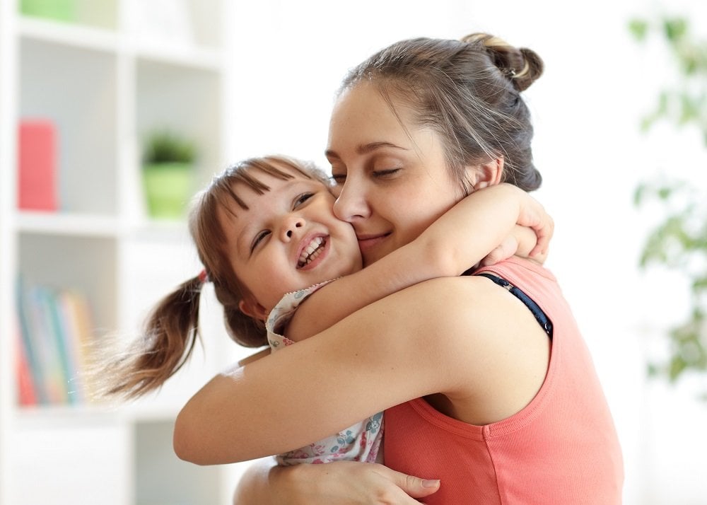 kleines Mädchen umarmt ihre Mutter