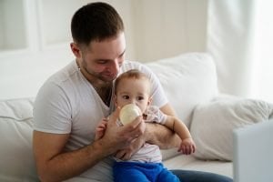 ein junger vater gibt seinem kind die flasche
