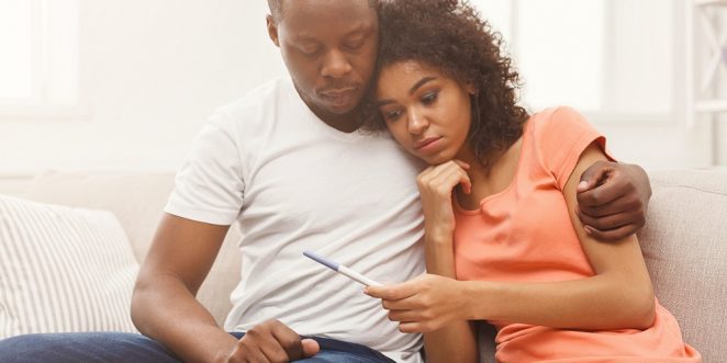 mann und frau schauen sich schwangerschaftstest an